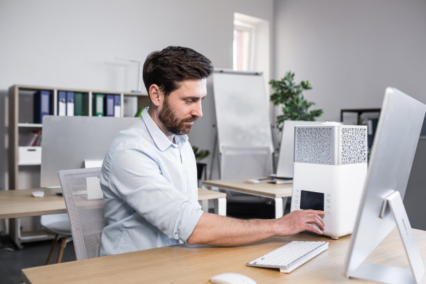 年轻帅哥，上班族，工作内容包括加湿器、空调，放在办公室电脑旁的桌子上图片下载