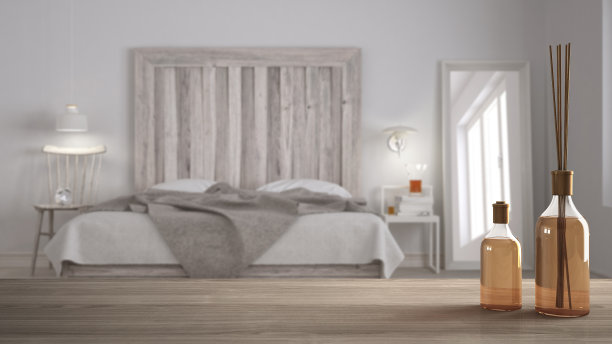 木制桌面或架子与芳香棒瓶子模糊的斯堪的纳维亚卧室自制床头板，白色建筑室内设计图片下载