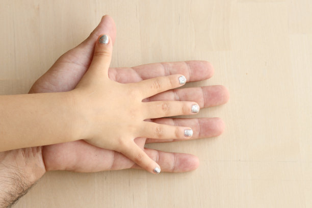 父母和女儿。小女孩的手和她爸爸的手。图片下载