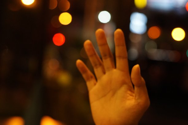 在夜间失焦背景上的手的照片图片下载