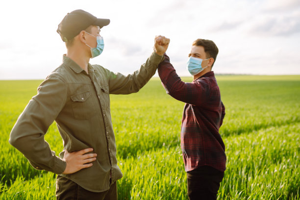 ． 戴着无菌口罩的农民在田间讨论农业问题。新型冠状病毒肺炎图片下载