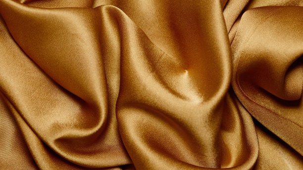 美丽的金色织物铺成波浪状图片下载