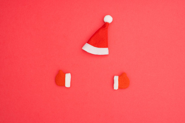 圣诞空白模板设计思路。圣诞老人的红色帽子和冬季手套对粉彩背景。复制空间为圣诞快乐的消息。图片下载