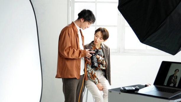 年轻男摄影师在摄影棚里拍照图片下载