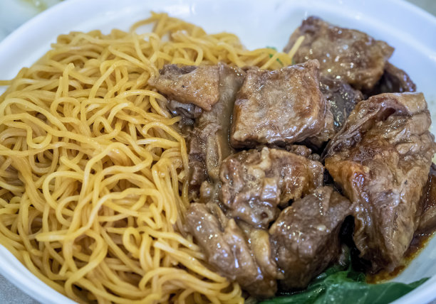 鲜嫩的红烧牛肉块配上新鲜的鸡蛋面图片下载