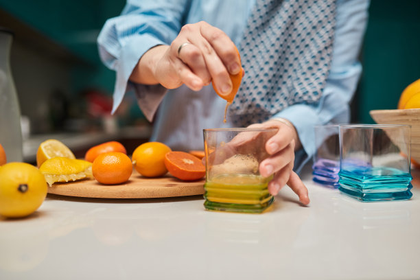 一张特写照片，一名妇女的手正在切割和准备水果，以制作健康的奶昔。健康生活方式的概念图片下载