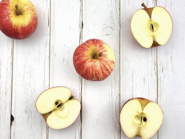 整个苹果切片，放在木纹背景上。图片下载