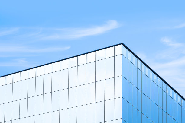 低角度的玻璃摩天大楼与阳光反射表面对蓝天背景图片下载