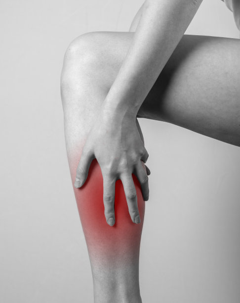 胫骨疼痛。女人抱着有红点的腿。肌腱、肌肉炎症、损伤、骨挫伤后果。黑和白。图片下载