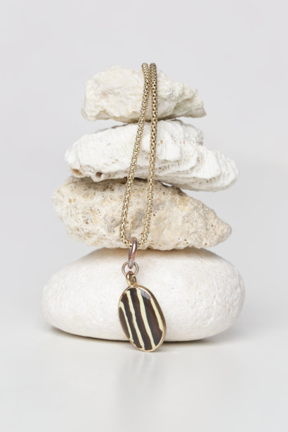 珠宝时装摄影。金项链与吊坠展示在装饰石头，工作室产品拍摄。图片下载