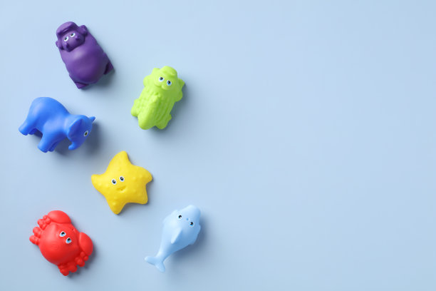 平面放置橡胶婴儿玩具洗澡在蓝色的背景与复制空间。前视图。图片下载