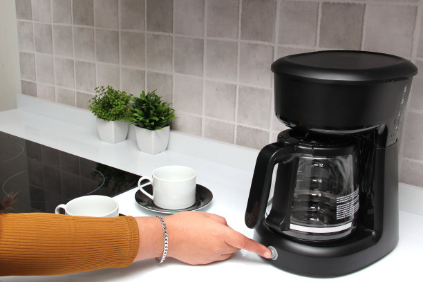 女人的双手在厨房的咖啡机里用清水和现磨咖啡为早餐准备美味而芳香的咖啡图片下载