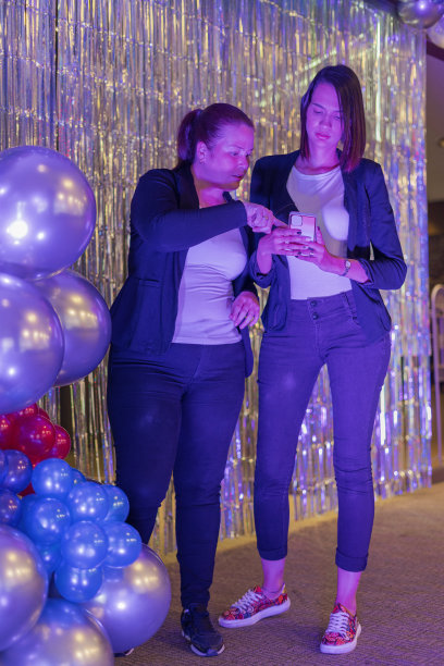 两名拉丁女性派对装饰师正在靠近她们的一个气球作品，分析小细节图片下载