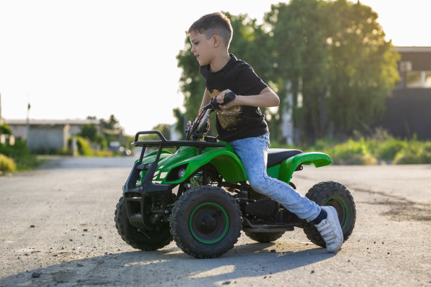 男孩骑着绿色的四轴马达图片下载