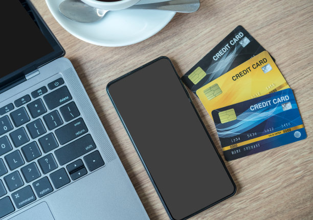 笔记本电脑信用卡，智能手机灰色的空白屏幕和木制背景的咖啡杯，网上银行的概念图片下载