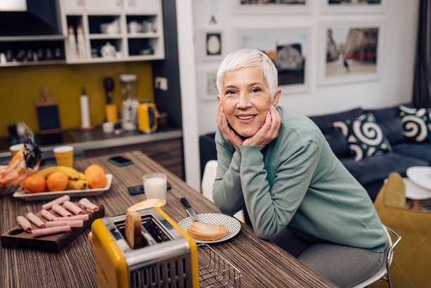 一位快乐的老年妇女在家享用早餐的肖像图片下载