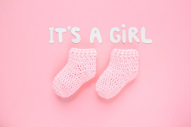 这是一个女孩在写字，粉色背景的钩针婴儿靴。图片下载