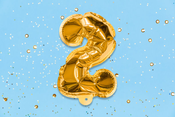 数字气球用金箔做成，数字2在蓝色的背景上用亮片装饰。生日贺卡图片下载