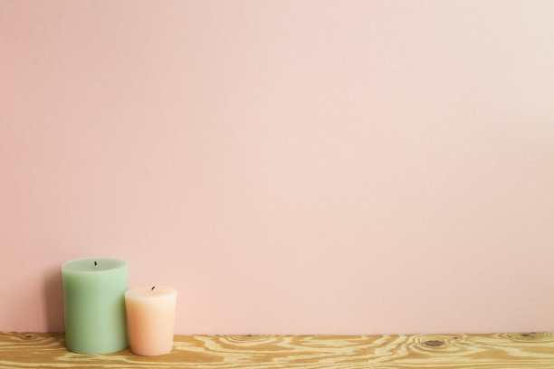 木桌上放着蜡烛。粉红色的背景墙图片下载
