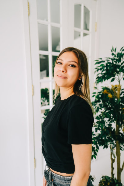 年轻开朗的女人站在自家花园里的肖像。图片下载