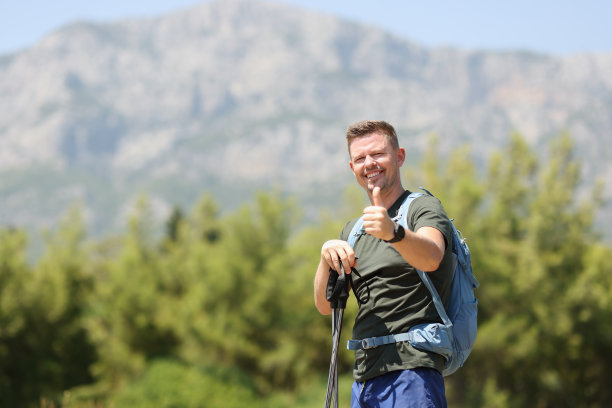 微笑的男人与斯堪的纳维亚手杖的背景山图片下载