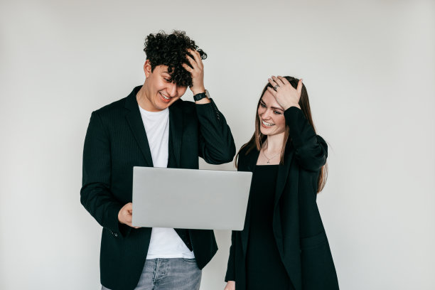 两个困惑、惊讶和震惊的女人和男人站在笔记本电脑前，看着屏幕。工作上的麻烦，难以置信图片下载