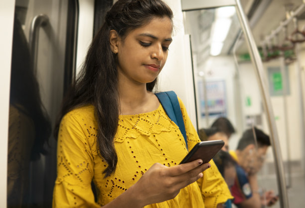 印度女人在地铁里使用智能手机的特写。图片下载