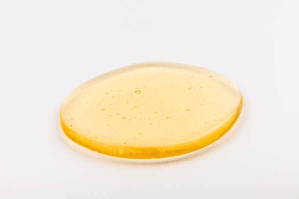 蜂蜜流。黄色的糖浆滴下来。天然产品和甜饮料。孤立在白色背景。图片下载