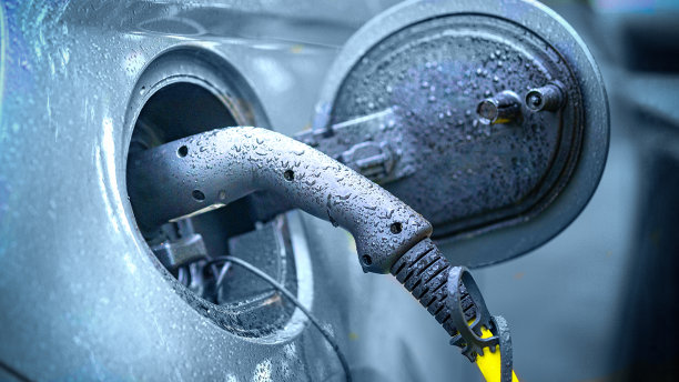 在雨中为混合动力汽车充电图片下载