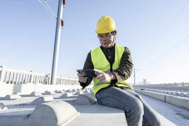 一名亚洲男性工程师在未完工的铁路工地拍照图片下载