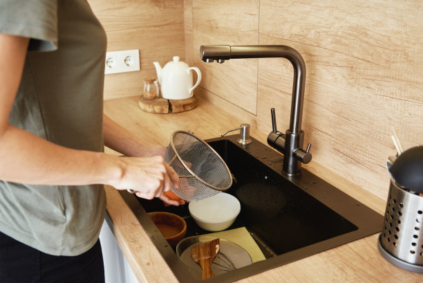 在厨房水槽里洗碗的女人图片下载