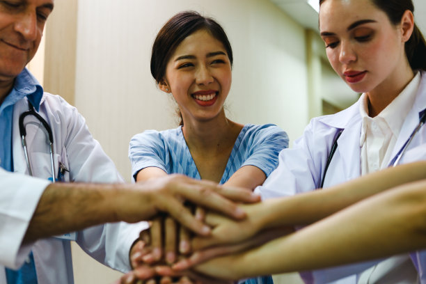 医生团队与轮椅上的病人交谈，询问症状和在医院的治疗。图片下载