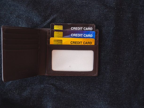 棕色皮革钱包上的牛仔裤背景。图片下载