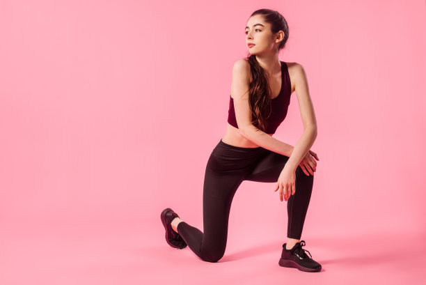 健身模型在运动服装在粉红色的背景图片下载