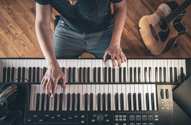 男人的手放在琴键上，俯视图。图片下载