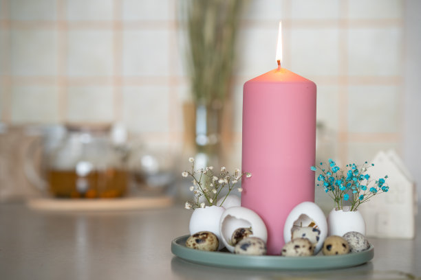 组成与一个大的粉红色蜡烛站在一个托盘周围的蛋壳装饰复活节图片下载
