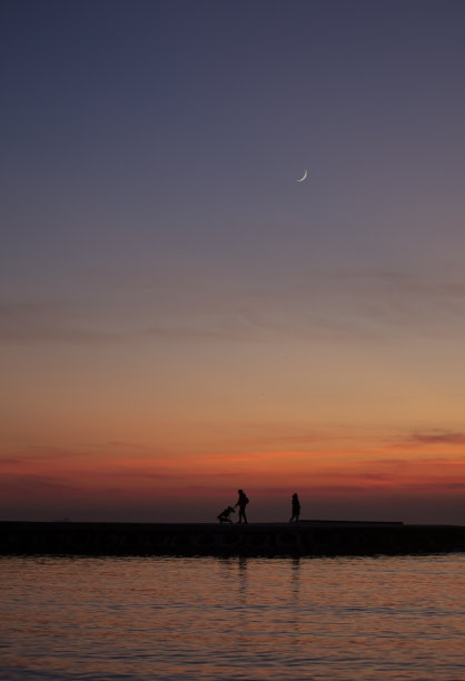 日落时分与新月下的家庭剪影图片下载