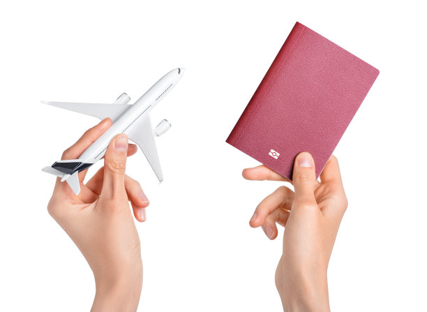 手拿着飞机和白色背景的红色护照。图片下载