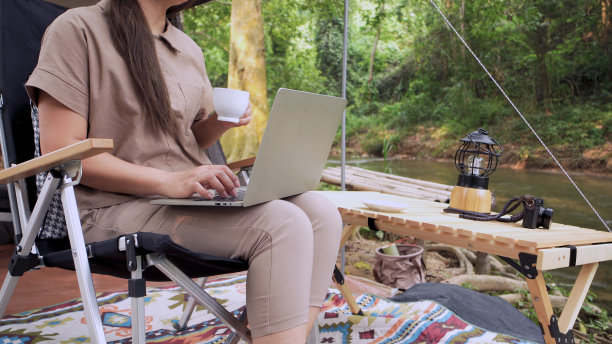 亚洲女性独自旅行和露营。商务女性在线工作和放松期间的旅行户外活动。图片下载