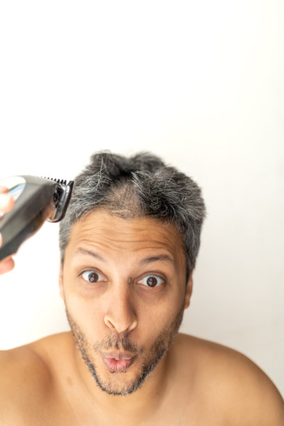 英俊的白发男子正在剪发。图片下载