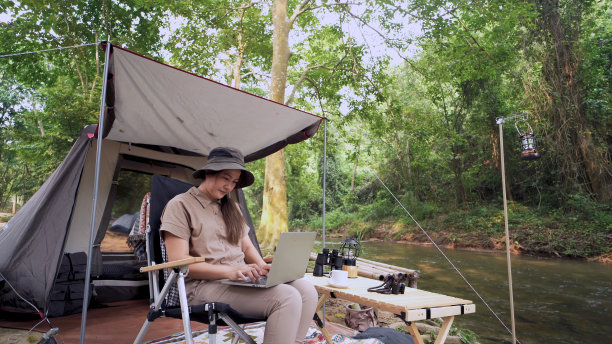 亚洲女性独自旅行和露营。商务女性在线工作和放松期间的旅行户外活动。图片下载