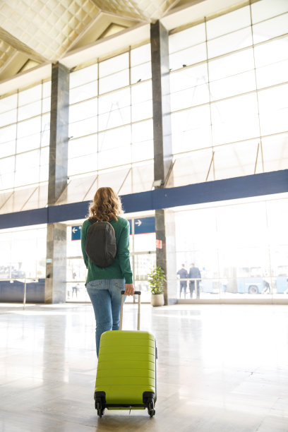 一个女人拖着行李箱穿过火车站，回家图片下载