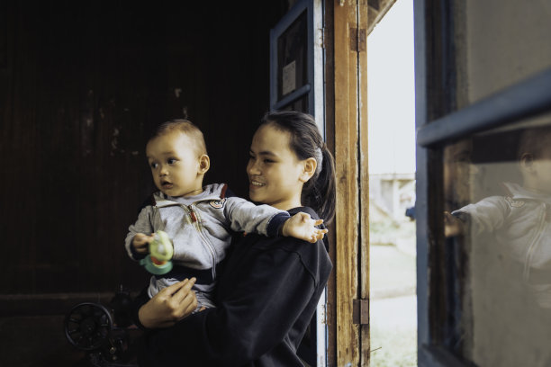 一个幸福的家庭的肖像，透过他们舒适的房子的窗户图片下载
