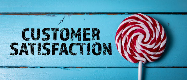 客户满意度。蓝色木质背景上的文字和红色棒棒糖图片下载