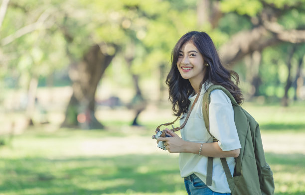 亚洲女性旅行者肖像摄影时尚生活方式与复古电影相机在夏季绿色公园。图片下载