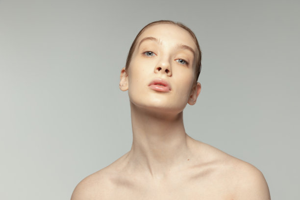 年轻温柔的女孩的肖像完美清晰的脸和丰满的嘴唇孤立在灰色的工作室背景。唇术图片下载