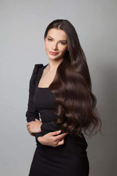 漂亮的年轻女子，棕色卷发。迷人的脸和自然的妆容图片下载