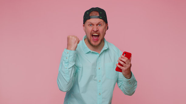 高兴兴奋的男子用手机说哇是的发现了大赢家的消息做着胜利者的手势图片下载