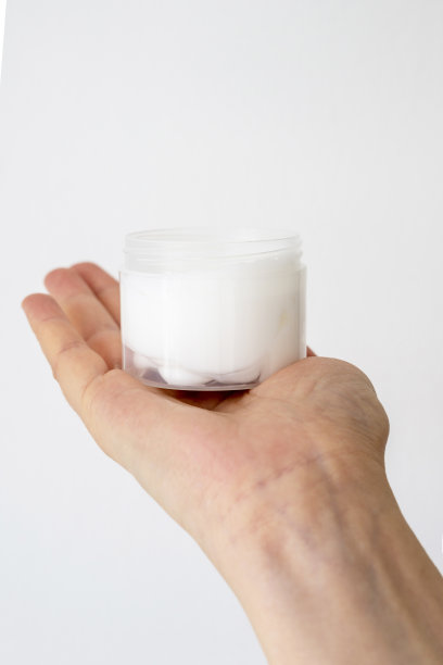 皮肤护理产品。女性手拿面霜罐在明亮的背景。美容护肤品图片下载