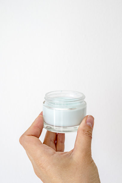 皮肤护理产品。女性手拿面霜罐在明亮的背景。美容护肤品图片下载
